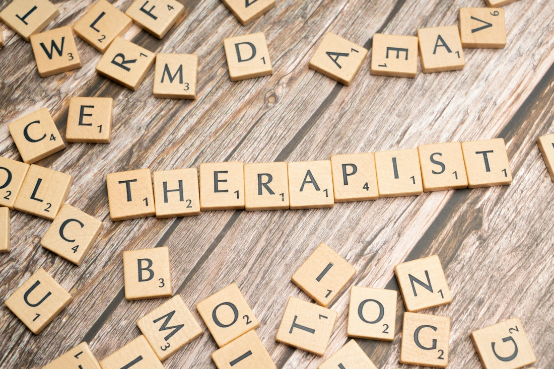 scrabble tiles spelling out the word therapy on a wooden surface