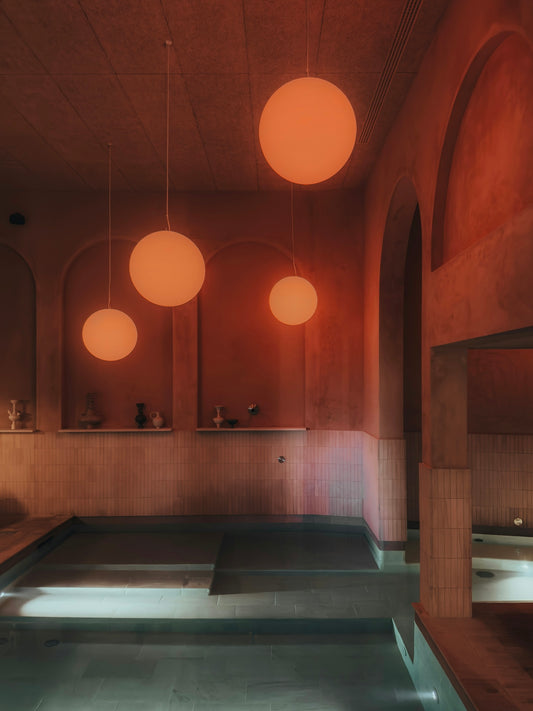 a large swimming pool with lights hanging from the ceiling